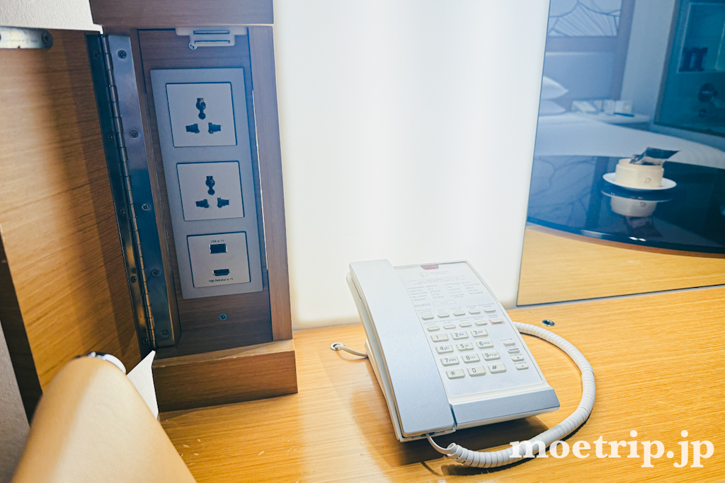 デスク側のコンセントは2口+USB/HDMIポート付き。電話もここに置かれていました。